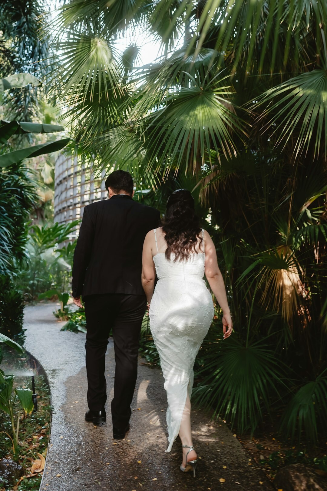 Danish bride and groom walking through a garden after their wedding