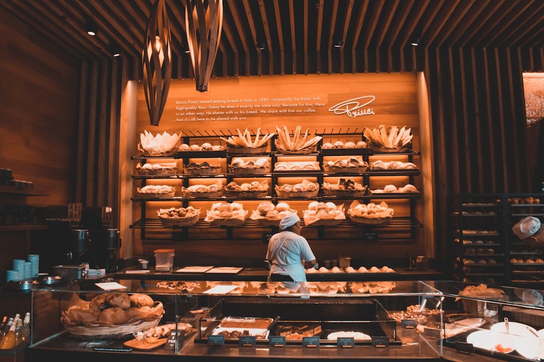 Danish baker holding a fresh loaf of bread in a bakery