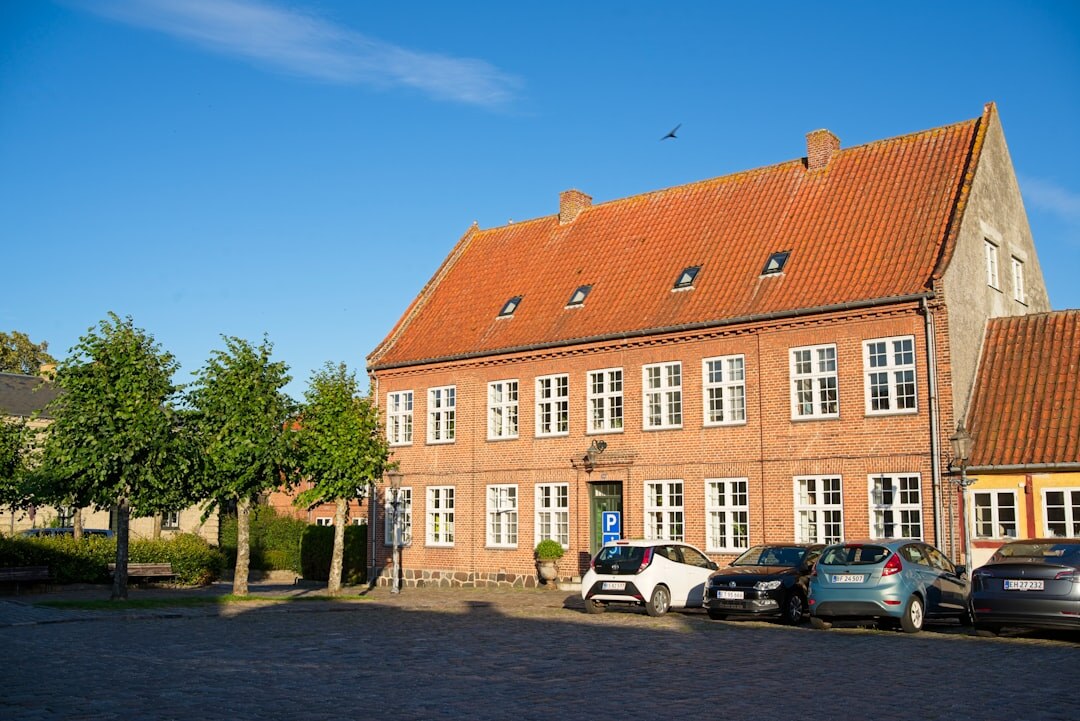 Documentary street photo of a quiet Danish town square at golden hour